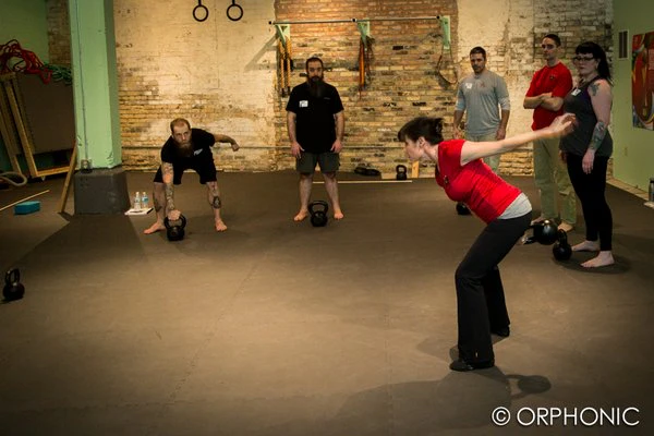 Andrea Du Cane, die am längsten tätige und erste weibliche Master RKC, zeigt einen ungefähr 80-Grad Hüft-Hinge mit dem einarmigen Swing.