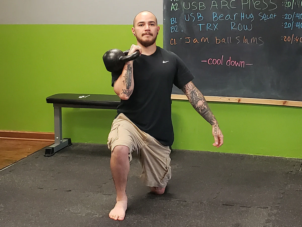 William Sturgeon, RKC-II führt einen halbknielenden Kettlebell-Druck aus