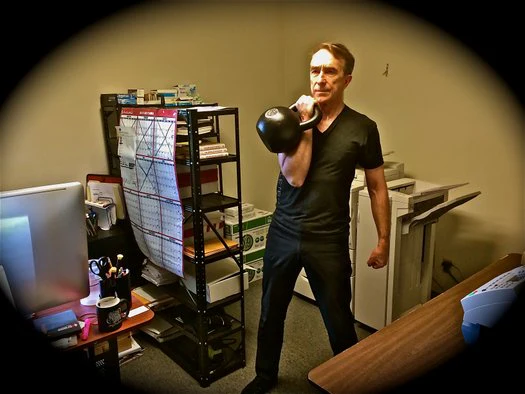 Büro-Workout John Du Cane führt 30 kg Kettlebell-Reinigungen im Dragon Door Büro aus