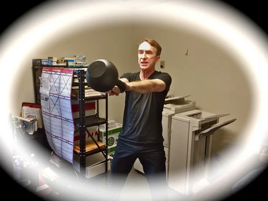 Büro-Workout John Du Cane führt 30 kg Kettlebell-Schwünge im Dragon Door Büro aus