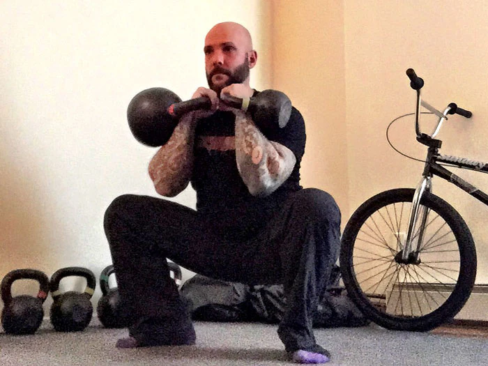 Steve Holiner Squat mit ungleichen Kettlebells