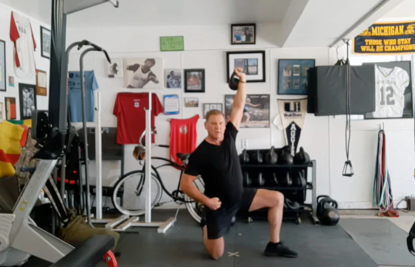 Dan John demonstriert einen Teil der Get-Down Press Sequenz mit einer leichten Kettlebell