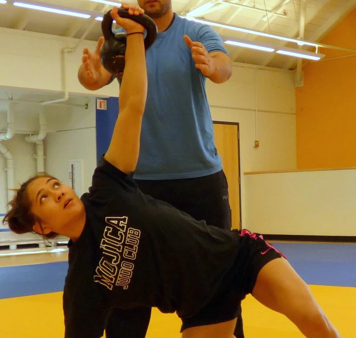 Ashoka McCormick spotting kettlebell get-up